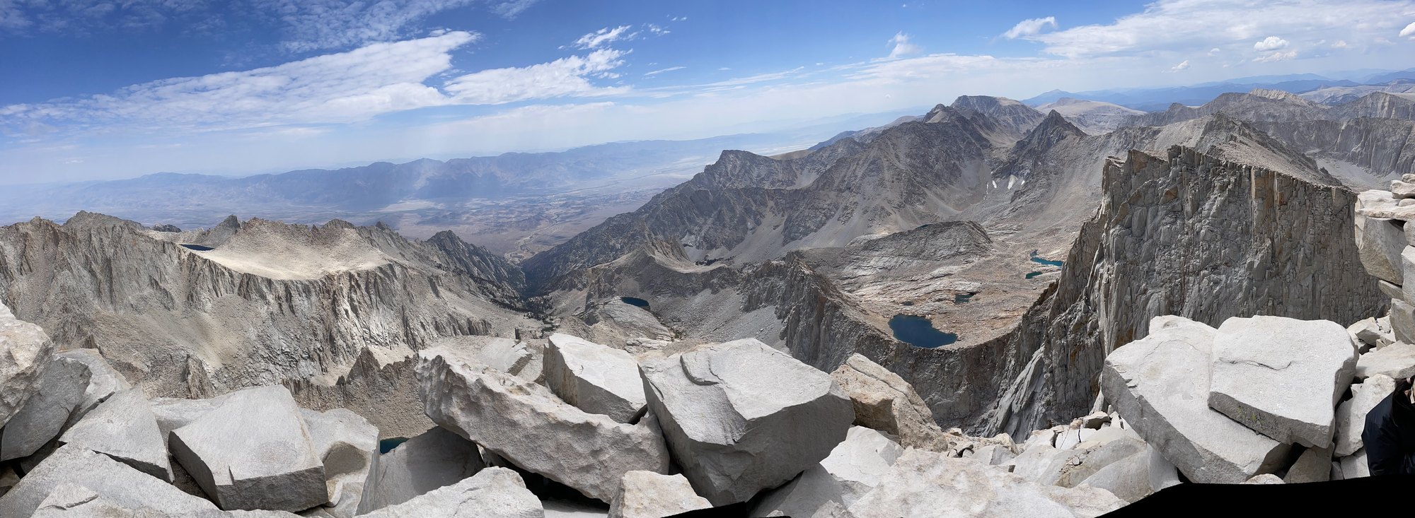 A wide rocky alpine basin with steep ridgelines and blue lakes.
